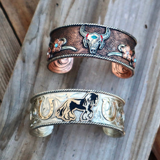 Copper and silver cuff bracelets on wood planks